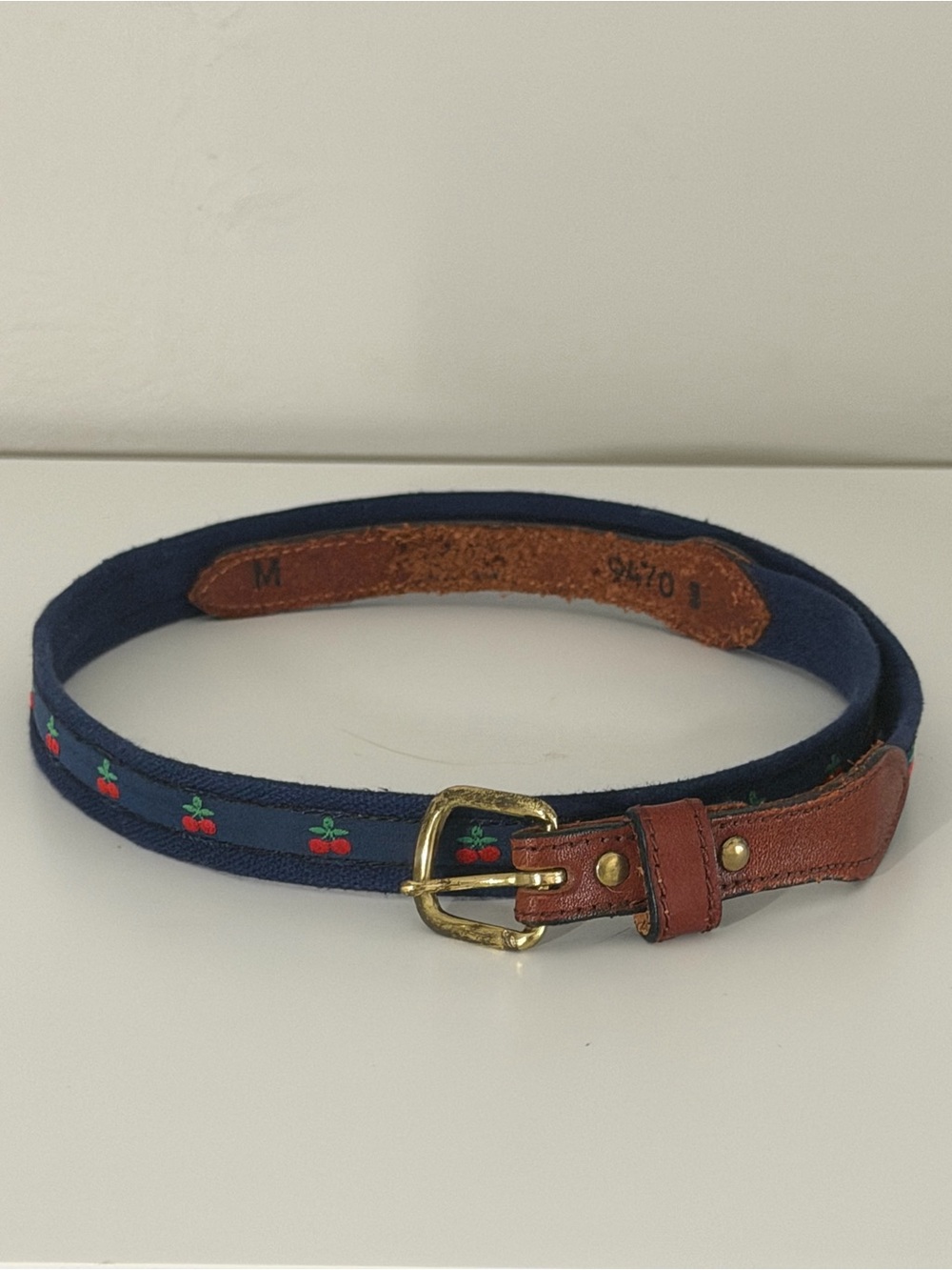 Adorable cherries belt on navy fabric leather and brass accents length approx 31